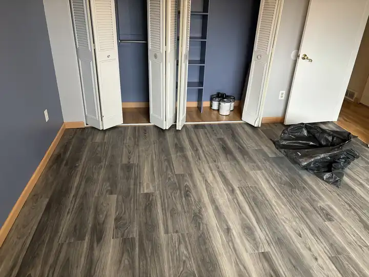 Grey plank laminate flooring laid through a bedroom to the closet doors