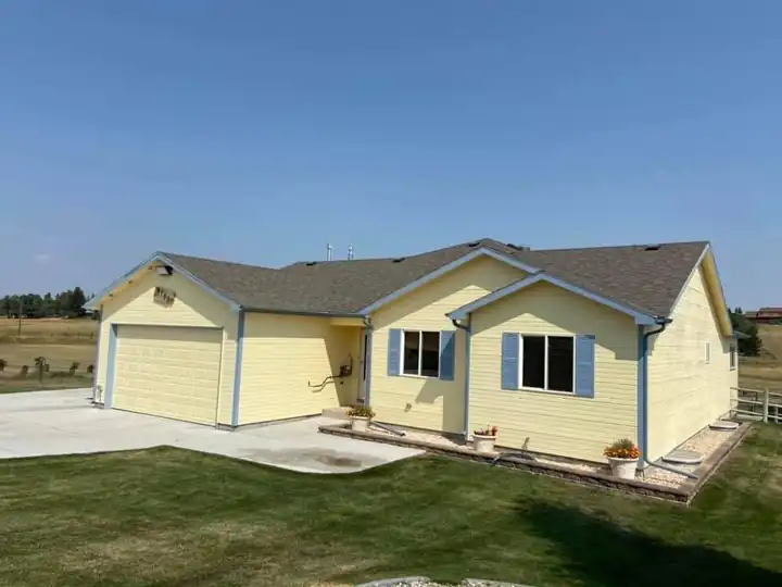 Yellow single-storey home with freshly painted siding and white trim