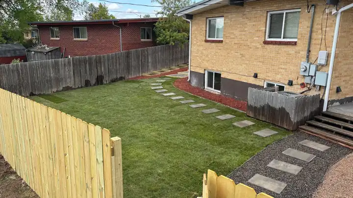 New sod with stepping stones beside a new fence