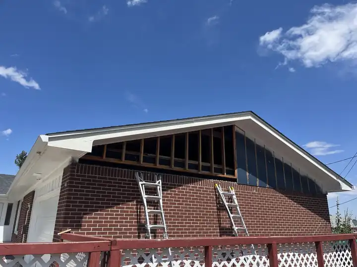 Brick house with the gable framing open and ladders up